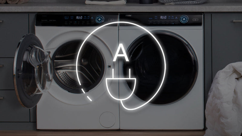 Lavatrice e asciugatrice poste una di fianco all'altra. Sovrapposto c'è un badge dedicato all'efficienza energetica di classe A.
