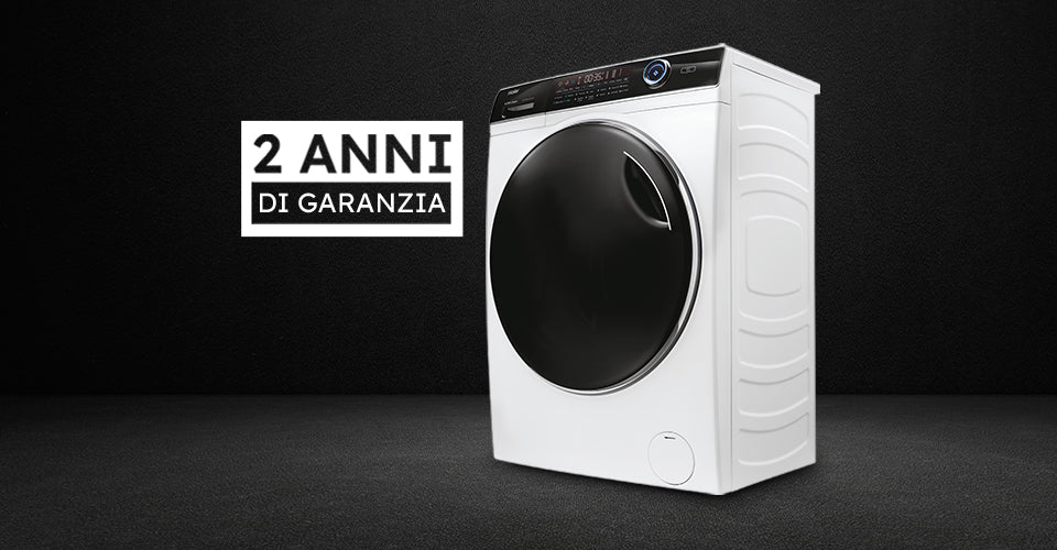 Lavatrice Haier bianca a carica frontale con oblò nero su sfondo scuro; testo '2 ANNI DI GARANZIA' a sinistra