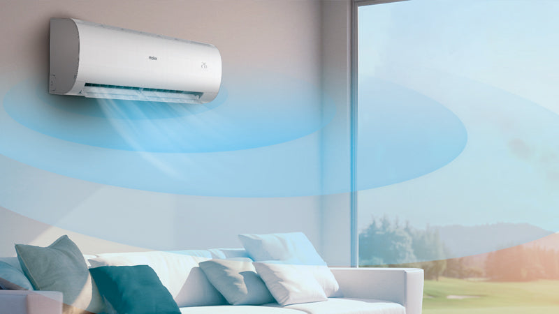Condizionatore Haier montato a parete in un soggiorno moderno, emette aria fresca su un divano con cuscini