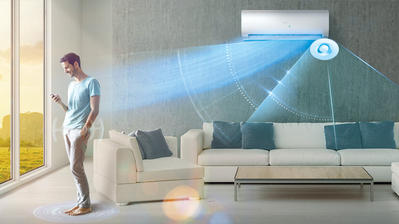 Uomo controlla il condizionatore Haier tramite smartphone, aria fresca distribuita uniformemente nel soggiorno