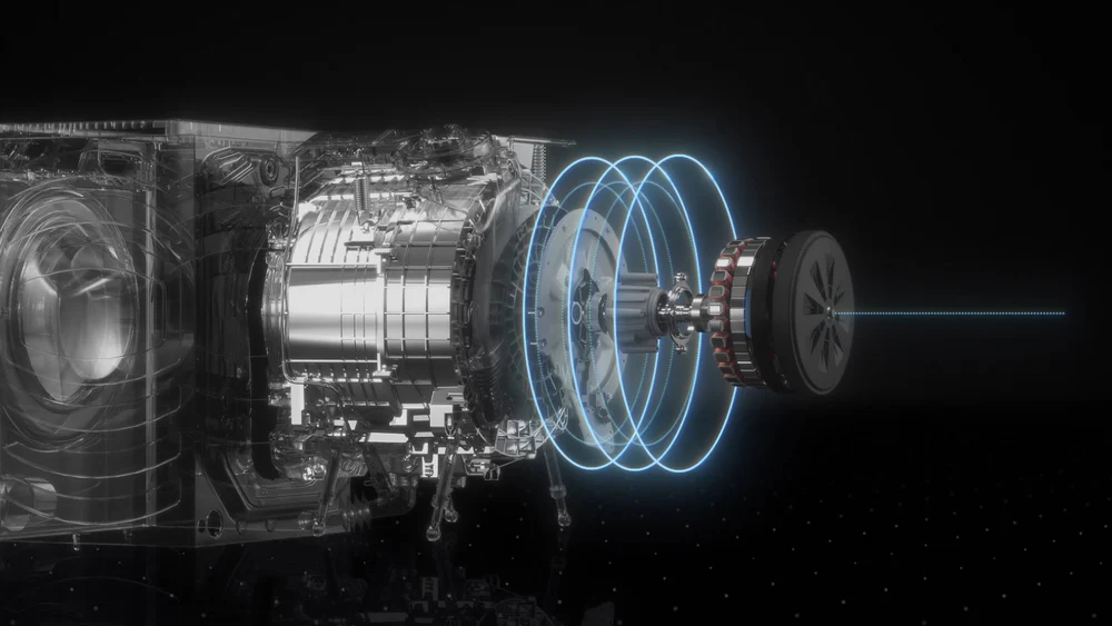 Vista esplosa dei componenti interni di una lavatrice, con evidenziazione grafica del movimento tramite cerchi blu.