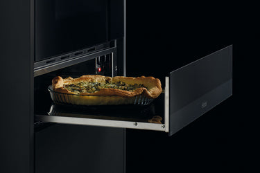 Cassetto scaldavivande che sta riscaldando una torta salata agli spinaci