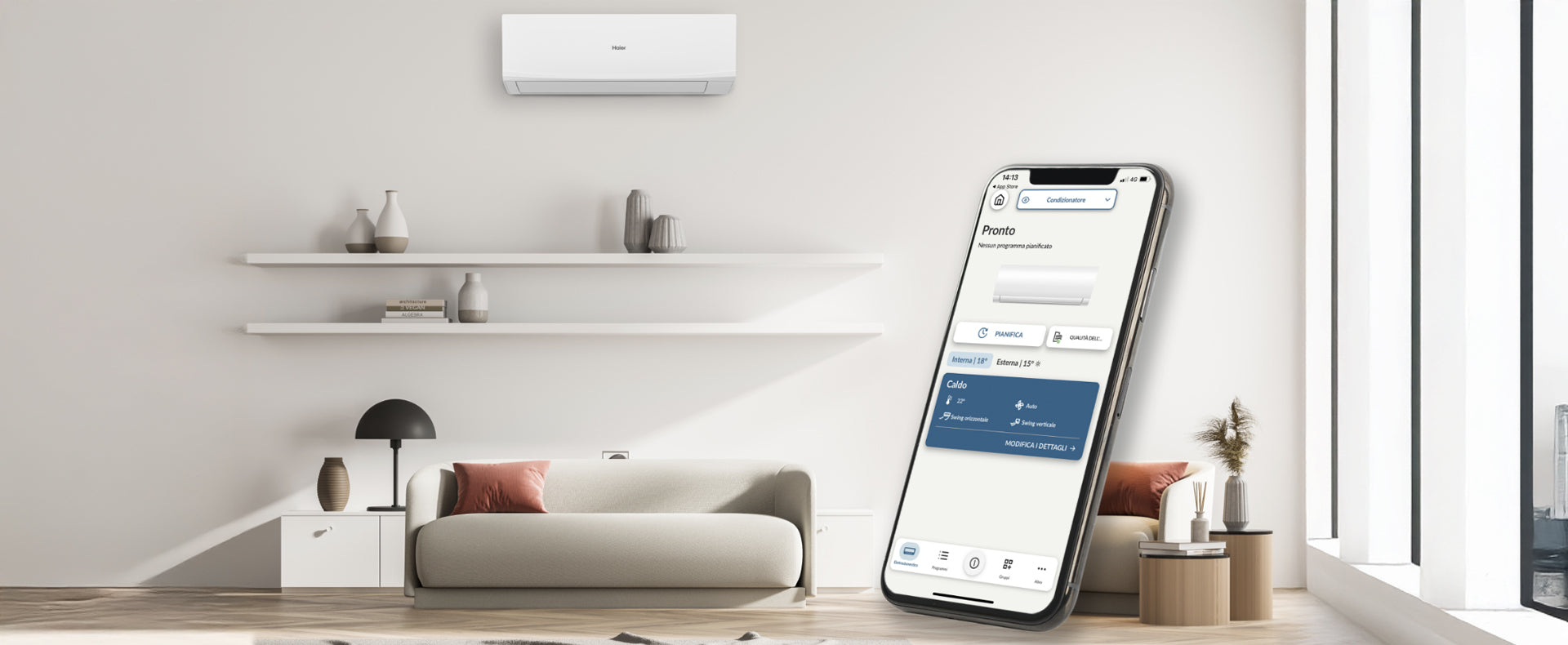 Salotto dotato di condizionatore. In primo piano si vede un telefono con l'app hon, attraverso la quale si può stabilire la temperatura del proprio condizionatore ed eventualmente pianificare l'accensione.
