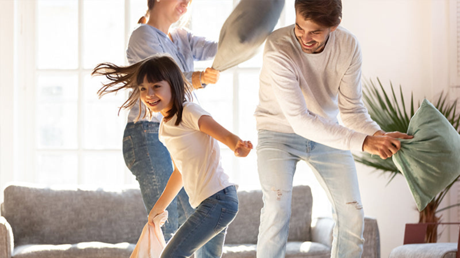 Famiglia felice che fa la battaglia dei cuscini.
