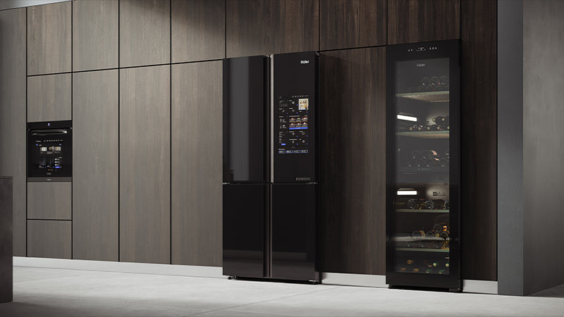 Cucina moderna con elettrodomestici Haier da incasso: forno, frigorifero con display digitale e cantinetta vino con porta in vetro