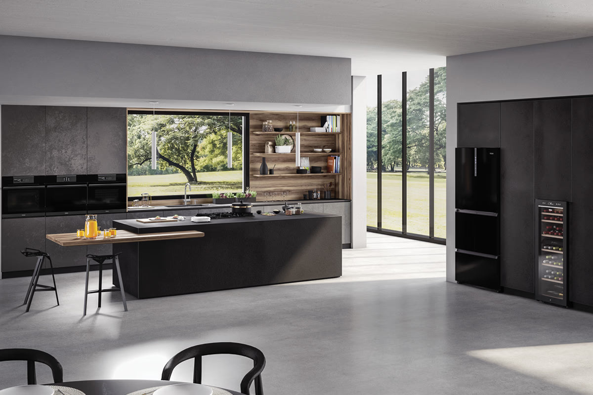 Cucina completa di tutti gli elettrodomestici: Forno, Microonde, Piano cottura, Frigorifero, Cantinetta vino. Nella cucina c'è una penisola con una pentola sul piano cottura a gas, il succo d'arancia sul tavolo. 