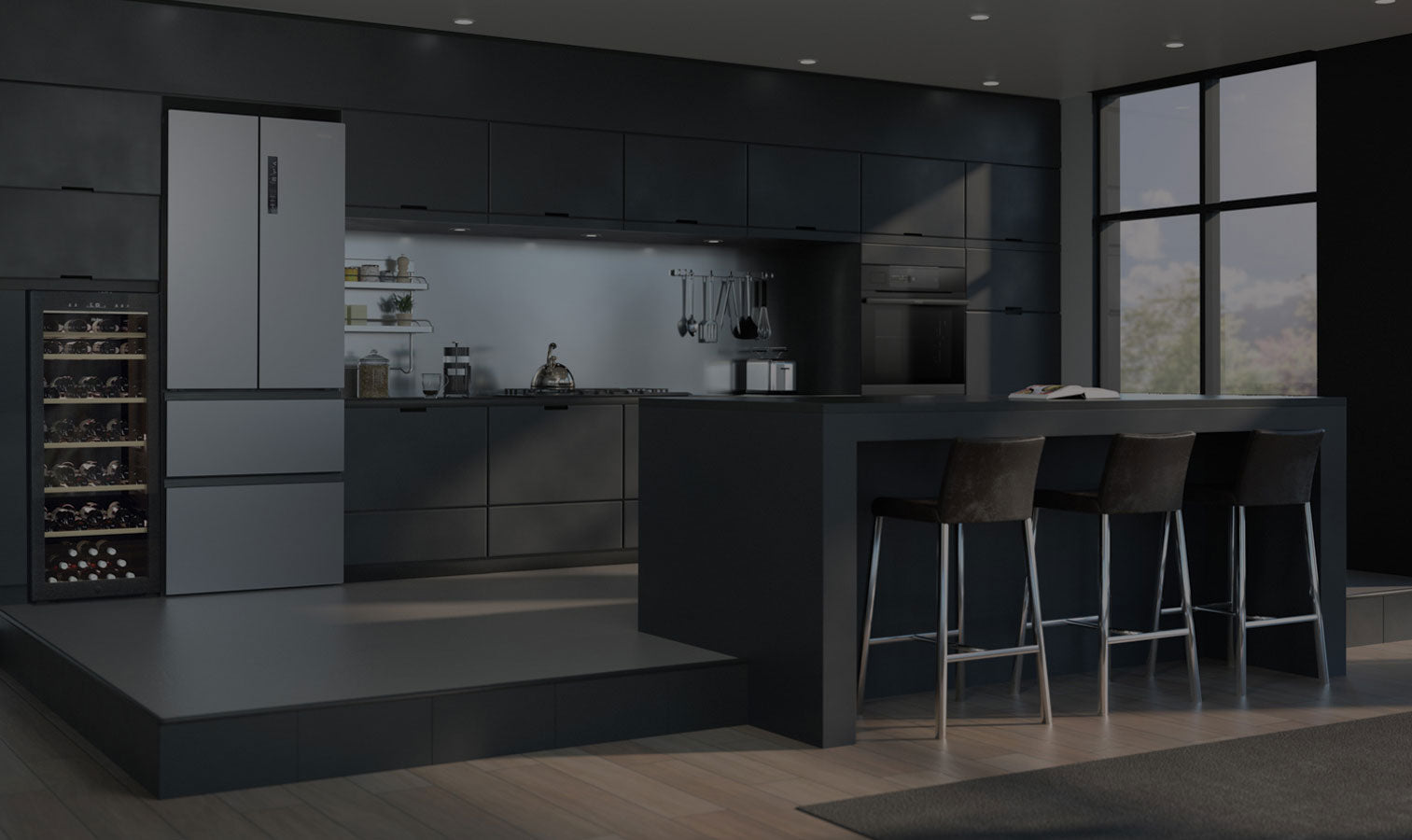 Cucina completa di elettrodomestici con focus su frigorifero inox, cantinetta vino, piano cottura a gas. Di fronte c'è una penisola. 