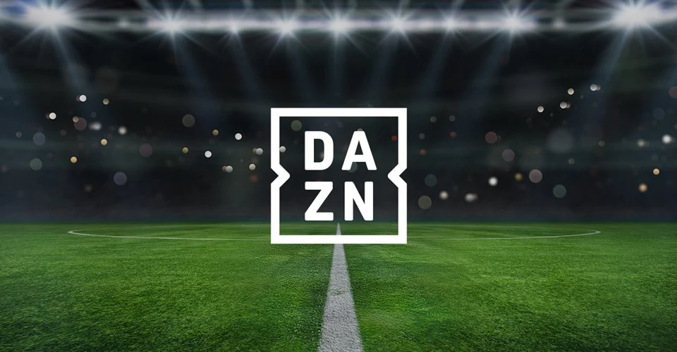 Immagine di un campo da calcio notturno con luci abbaglianti sopra e un logo centrale di DAZN che sovrasta il campo.