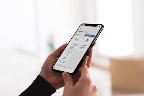 Persona che tiene in mano un telefono mentre usa l'app hOn